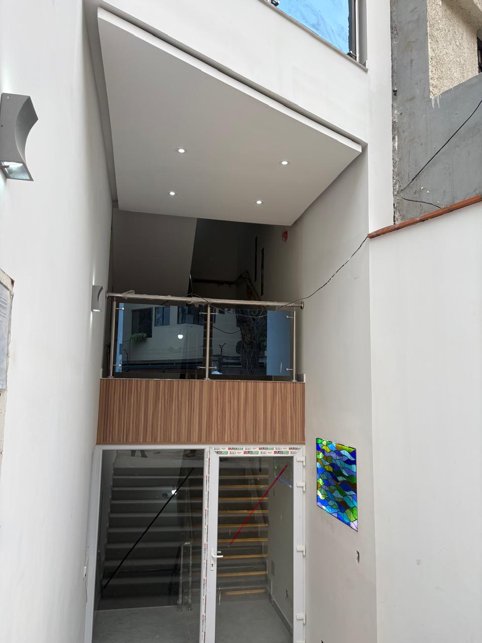 Lobby de doble altura con mural de vidrio