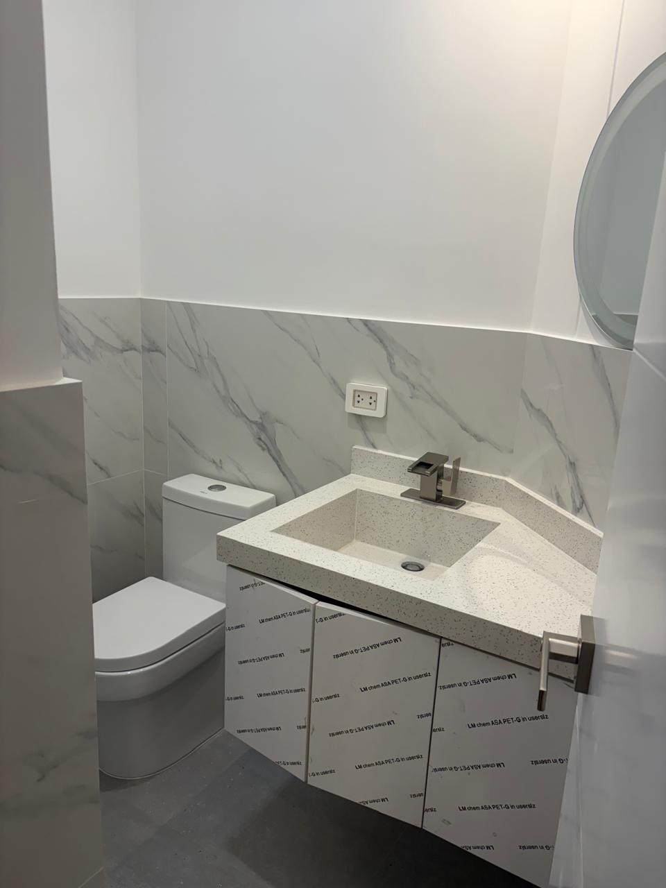 Baño — mármol y espejo redondo